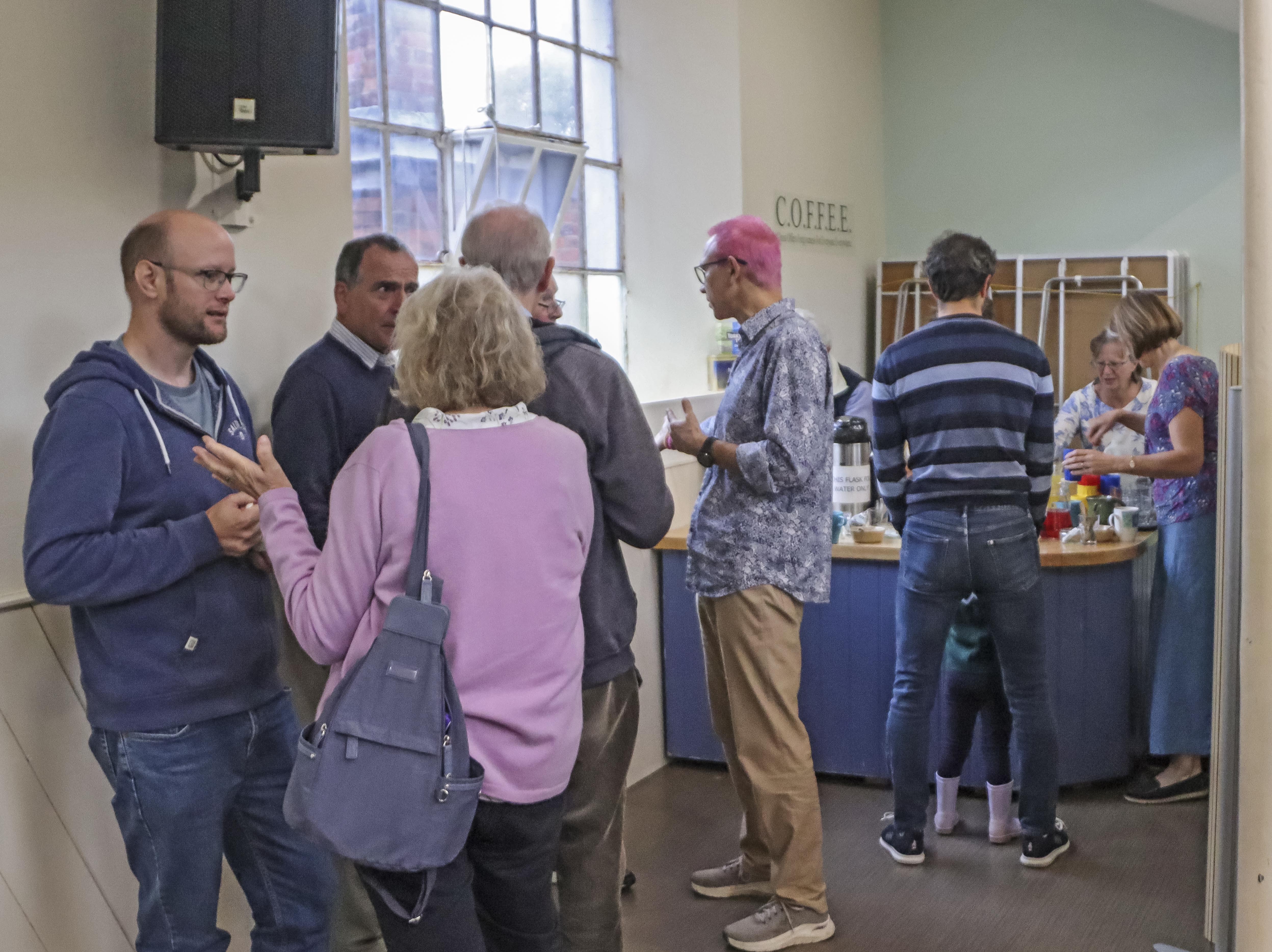 A group of people chatting and drinking coffee