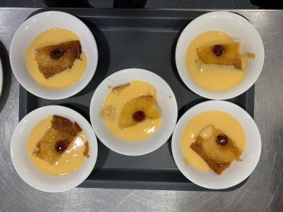 5 bowls of pineapple upside down pudding and custard